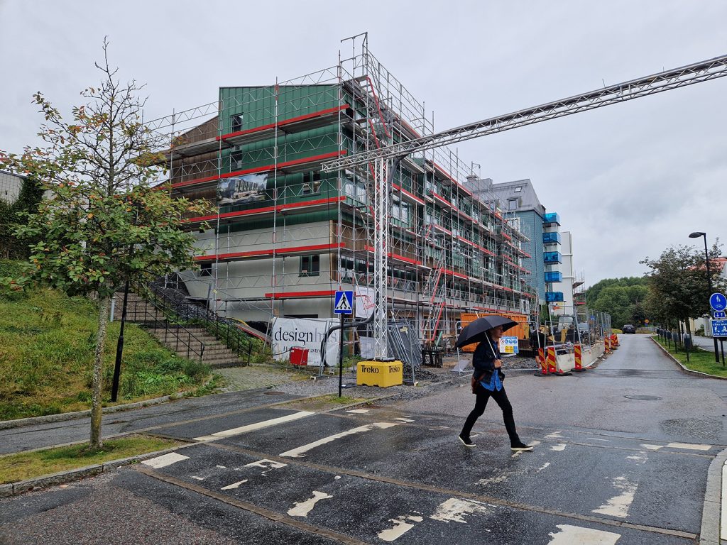 Stadsradhusen i Sollentuna sedda från gatan. Herman Arfwedsson korsar övergångstället.